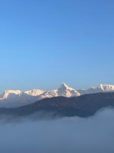 vistas a una cordillera con montañas cubiertas de nieve en Himalaya Serene View Guest House & Farm Stay, en Deorāli