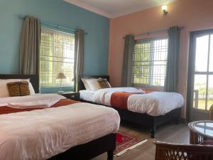 Un dormitorio con dos camas y dos ventanas. en Himalaya Serene View Guest House & Farm Stay, en Deorāli