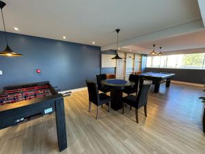 a room with two ping pong tables and chairs at Apartamento com vista imperdível in Laguna