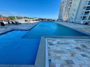 a large blue swimming pool in a building at Apartamento com vista imperdível in Laguna