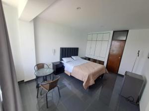 a bedroom with a bed and a table and chairs at Hotel Kendari - Chincha in Chincha +65 photos
