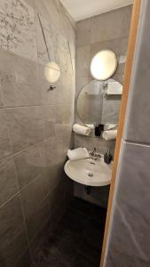 a bathroom with a sink and a mirror at Soho Guesthouses in Düsseldorf