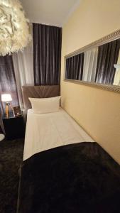 a hotel room with a bed in front of two windows at Soho Guesthouses in Düsseldorf +6 photos