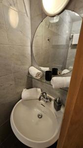 a bathroom with a sink and a mirror and towels at Soho Guesthouses in Düsseldorf