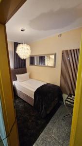 a bedroom with a bed and a chandelier at Soho Guesthouses in Düsseldorf