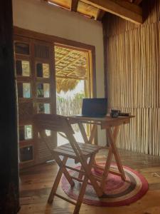 a wooden desk with a laptop sitting on top of it at Hostal Onahu Chacahua in Guayabas +37 photos