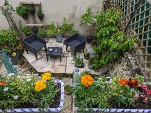 a garden with flowers and tables and chairs at L'appartement Paulange in Laprade