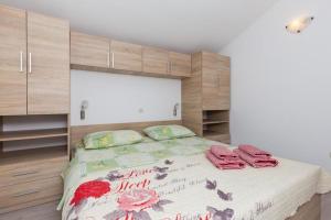 een slaapkamer met een groot bed met houten kasten bij One Bedroom Apartment with Balcony and Sea View CRVENI in Ston