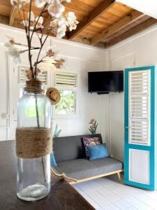 a vase with flowers on a table in a room at Kya's Bungalow - Proche des plages in Le Marin