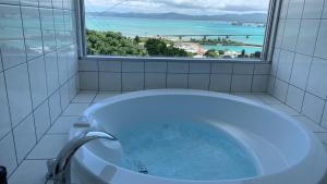 今归仁村シーブリーズ古宇利的带窗户的浴室里的浴缸