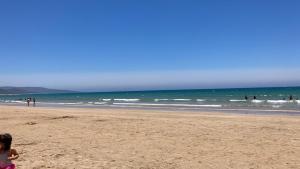 a child walking on a beach with people in the ocean at Piso Barbate in Barbate