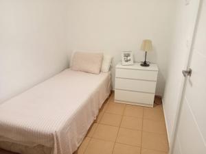 a small bedroom with a bed and a night stand at Piso Barbate in Barbate +3 photos