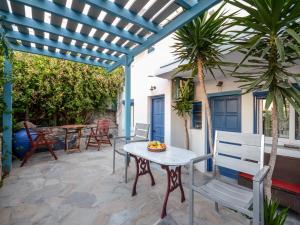 patio ze stołem i krzesłami pod pergolą w obiekcie Sofia Studios w mieście Agia Anna (Naxos)
