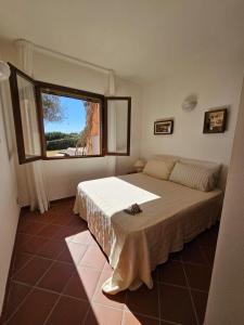 a bedroom with a bed and a large window at Bellavista, Stintino la pelosa in Cuile Pazzoni +24 photos