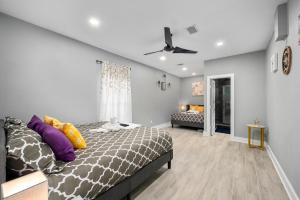 ヒューストンにあるModern & Spacious 1BR Haven near Galleriaのベッドルーム1室(紫と黄色の枕が備わるベッド1台付)