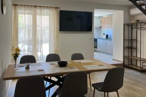 a dining room table with chairs and a television on a wall at Holiday house with a parking space Bilice, Krka - 24006 in Šibenik +7 photos