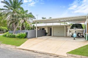 a house with a garage with a car parked in it at 4 Bedroom House at Holloways Beach in Holloways Beach