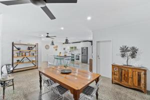 a living room with a wooden table and a kitchen at 4 Bedroom House at Holloways Beach in Holloways Beach