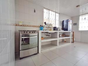 a white kitchen with a stove and a sink at Casa Campestre - Villa Isabel in Paipa