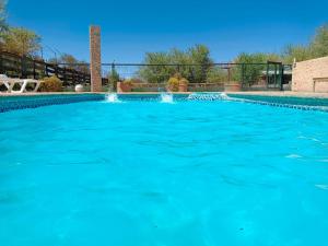a large swimming pool with blue water at Cabañas el Chañar in San Pedro de Atacama