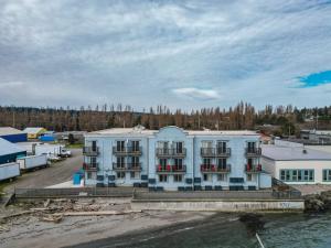 a large white building next to a body of water at Water Front Inn in Port Townsend