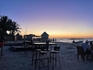 a group of tables and chairs on the beach at Casa Holboxeños in Holbox Island