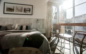 um quarto com uma cama e uma grande janela em Casa Galos Hotel & Lofts em Valparaíso