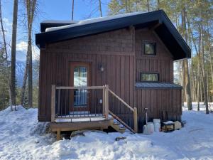 a small cabin with a porch in the snow at Alder House in Golden