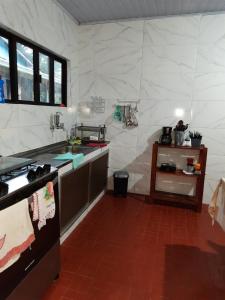 a kitchen with a large white tiled wall at Casadateca in Praia Vermelha