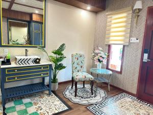 a bathroom with a vanity and a chair and a mirror at Romance Hotel in Ho Chi Minh City