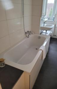 a white bathroom with a tub and a sink at Urlaub Oase in Coswig +16 photos