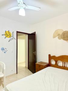 a bedroom with a bed and a ceiling fan at Apartamento pé na areia de frente para o mar in Mongaguá