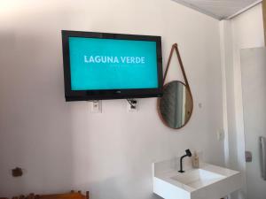 a flat screen tv hanging on a white wall at Canto do Mar Suíte in Barra Grande