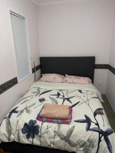 a bedroom with a bed with a black headboard at Cozy room in Pokeno