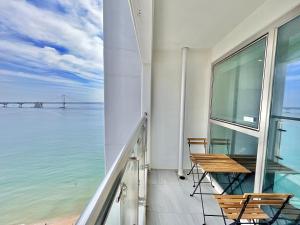 a balcony with chairs and a view of the ocean at The First Hyoistay Gwangan in Busan