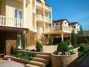 a large apartment building with stairs in a yard at Buhta Udachi Mini-hotel in Gelendzhik