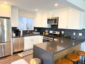Una cocina con gabinetes blancos y electrodomésticos de acero inoxidable. en Central North Hollywood Home, en Los Ángeles