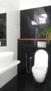 a bathroom with a white toilet and a sink at Majestic Apartments in Nawala