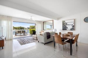a living room with a table and chairs and a dining room at Driftwood 6 Private Beach Stay in Noosaville