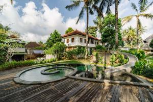 a house with a swimming pool in front of a house at Hemma Human Home in Ubud