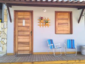 two chairs sitting on the porch of a house at Canto do Mar Suíte in Marau