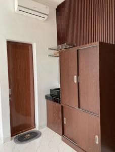 a room with wooden cabinets and a door at Laika Homestay in Gondowulung