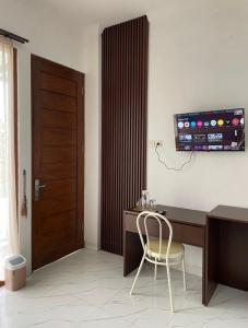 a desk with a chair in a room with a door at Laika Homestay in Gondowulung