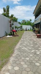 a group of people working on a sidewalk next to a building at Laika Homestay in Gondowulung