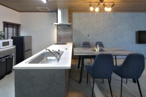 a kitchen with a sink and a table with chairs at GuestHouse Le Repos in Bihoro
