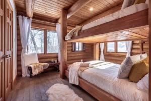 a bedroom with two bunk beds in a log cabin at Chalet du Lac Rougeaud in Mont-Blanc