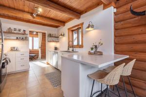 a kitchen with white counters and wooden walls at Chalet du Lac Rougeaud in Mont-Blanc +32 photos