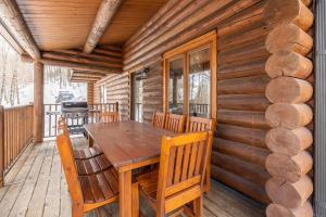 a wooden table and chairs on the deck of a cabin at Chalet du Lac Rougeaud in Mont-Blanc