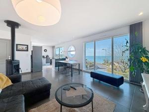 una sala de estar con un sofá y una mesa en Villa à 150m de la plage avec piscine et WiFi gratuit - FR-1-361-8, en Donville-les-Bains