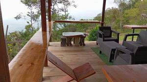 a wooden deck with chairs and a table and a table at Buena Vista Ecohotel in Los Medios